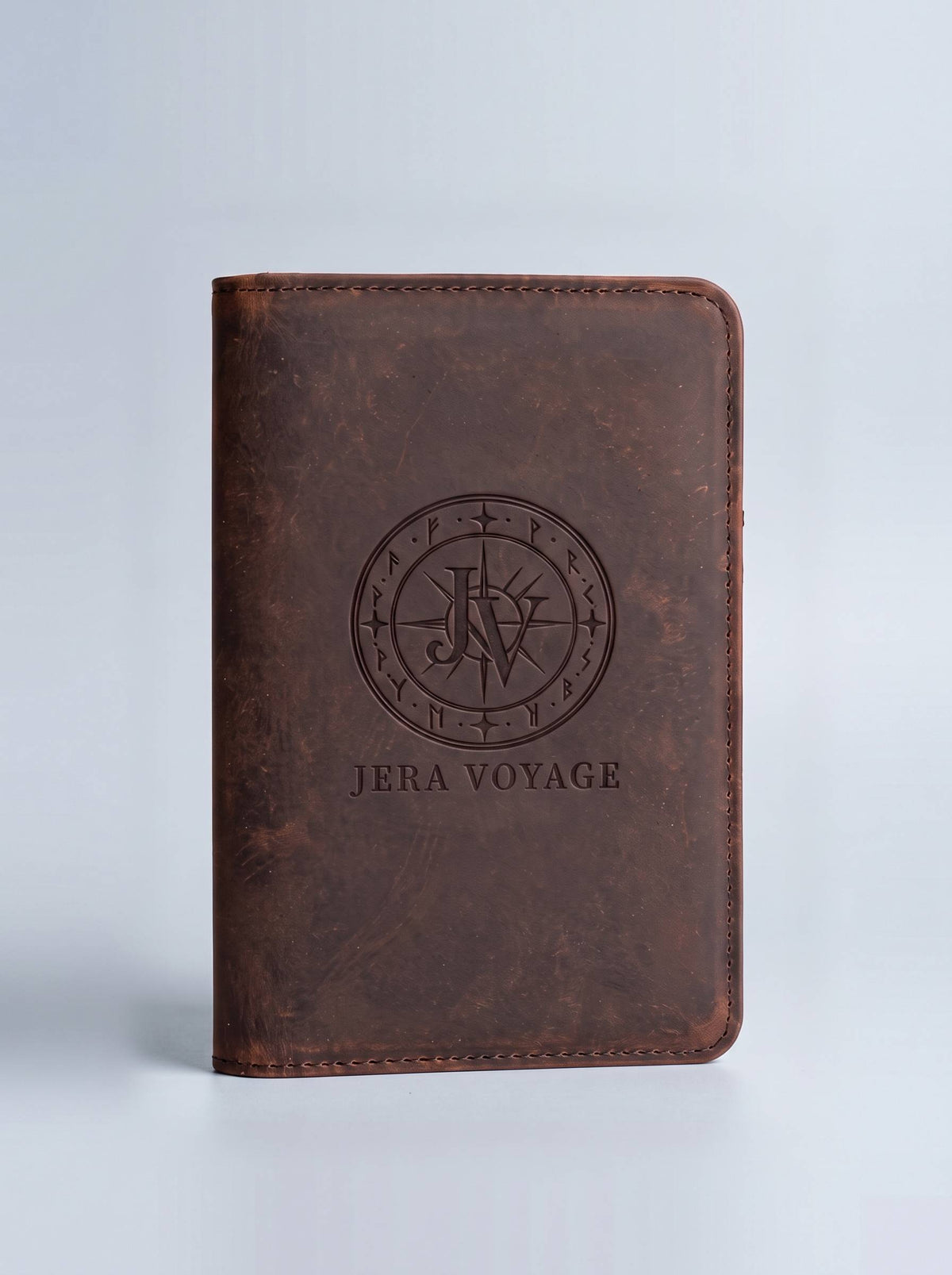 The Heritage Leather Passport Cover in espresso, front view with the debossed Jera Voyage seal